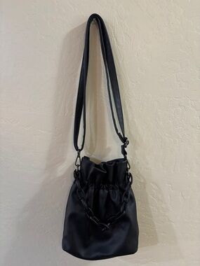Sleek Black Drawstring Shoulder Bag with Chain Accent